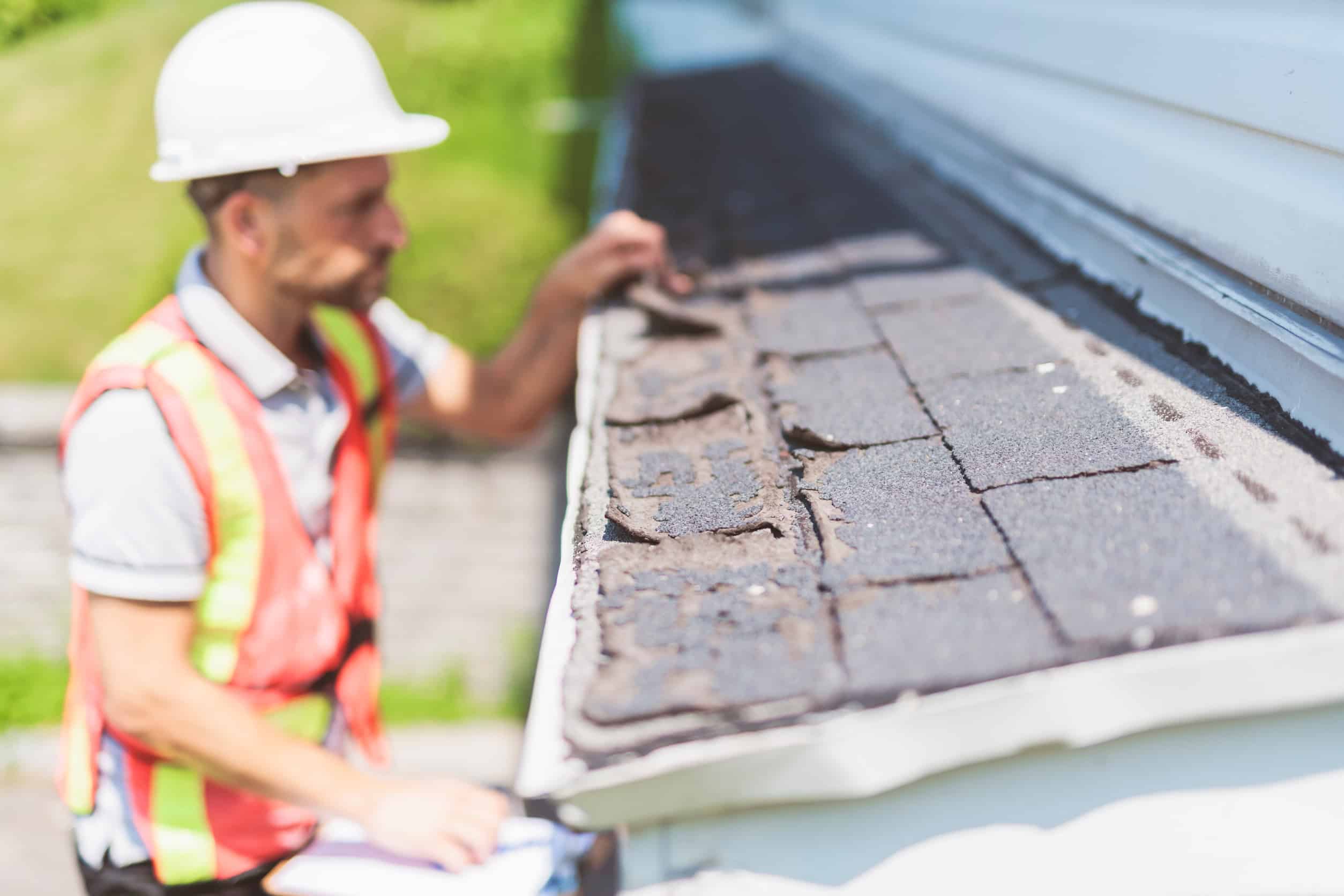 Inspection de toiture par un ouvrier en sécurité.
