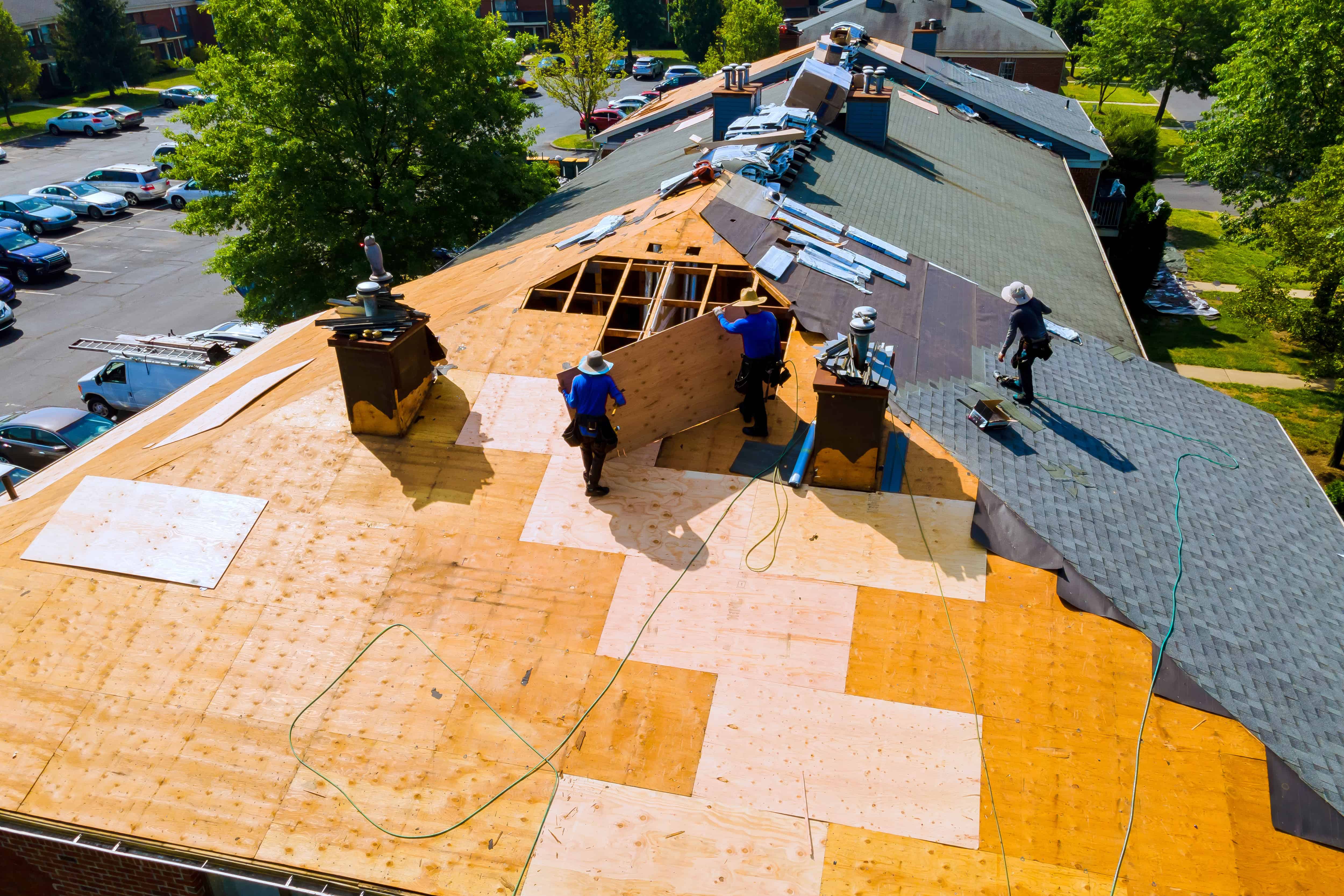 Travailleurs installant un toit en bois et en ardoise.
