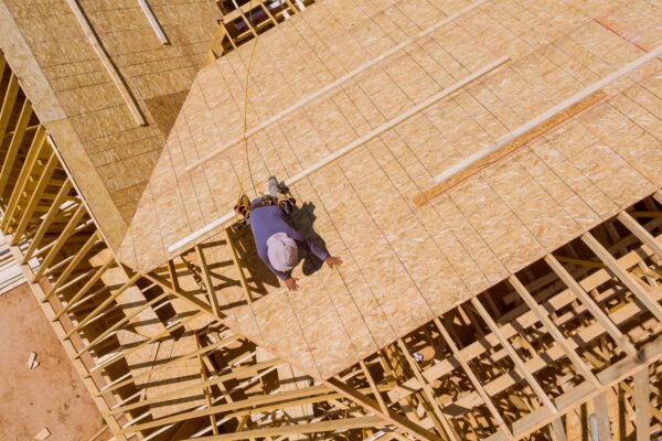 Travailleur sur charpente de toit en construction